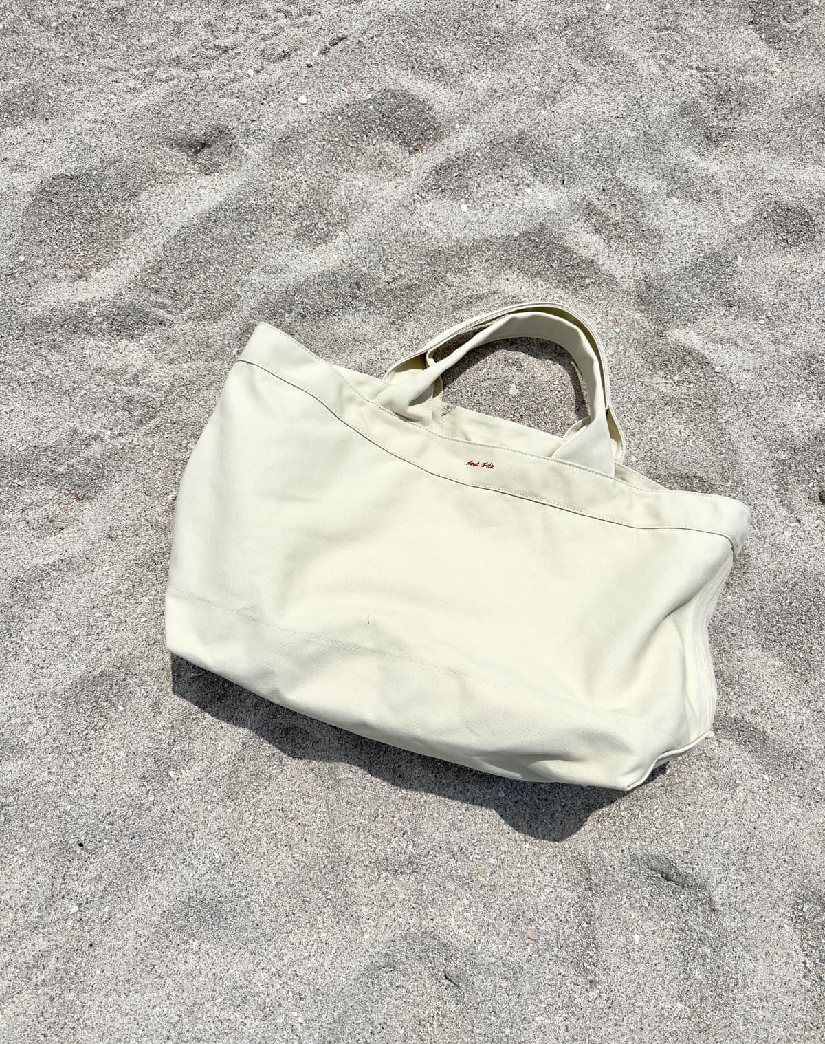 Oversized beach tote on sand - premium canvas with silver protective studs