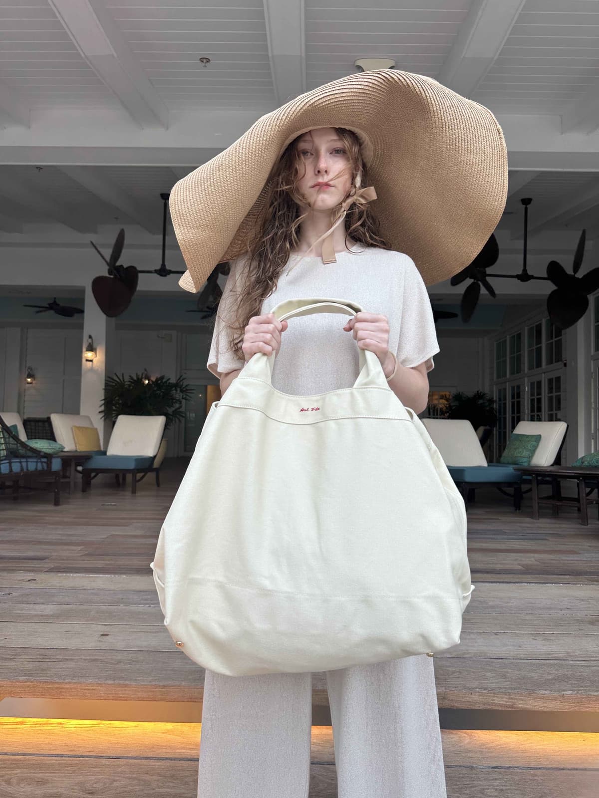 Structured canvas tote paired with oversized sun hat - yacht beach bag